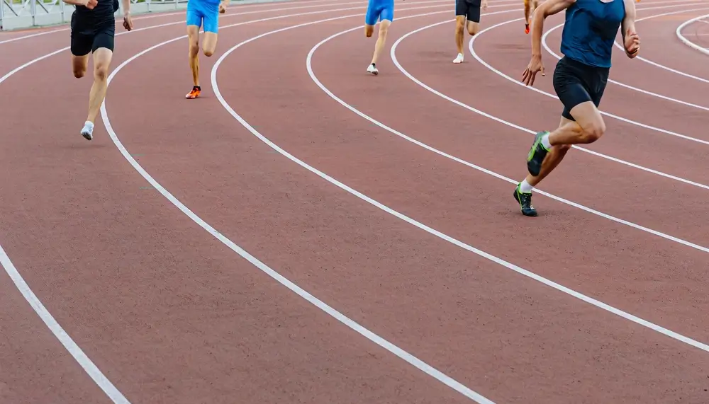 Candidates running on an athletic track for a police fitness bleep test assessment.