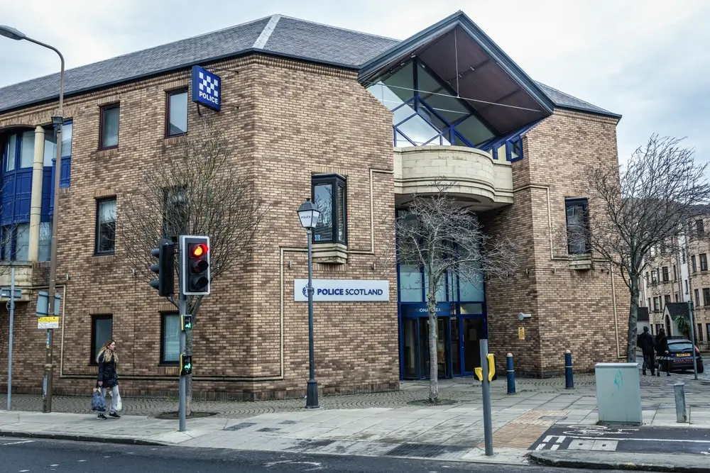 Exterior of a modern police station building with brick architecture and Police Scotland signage.