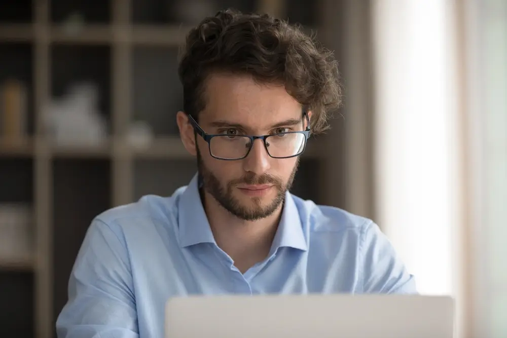 Focused person taking exam online on a laptop for a Police Scotland recruitment application.
