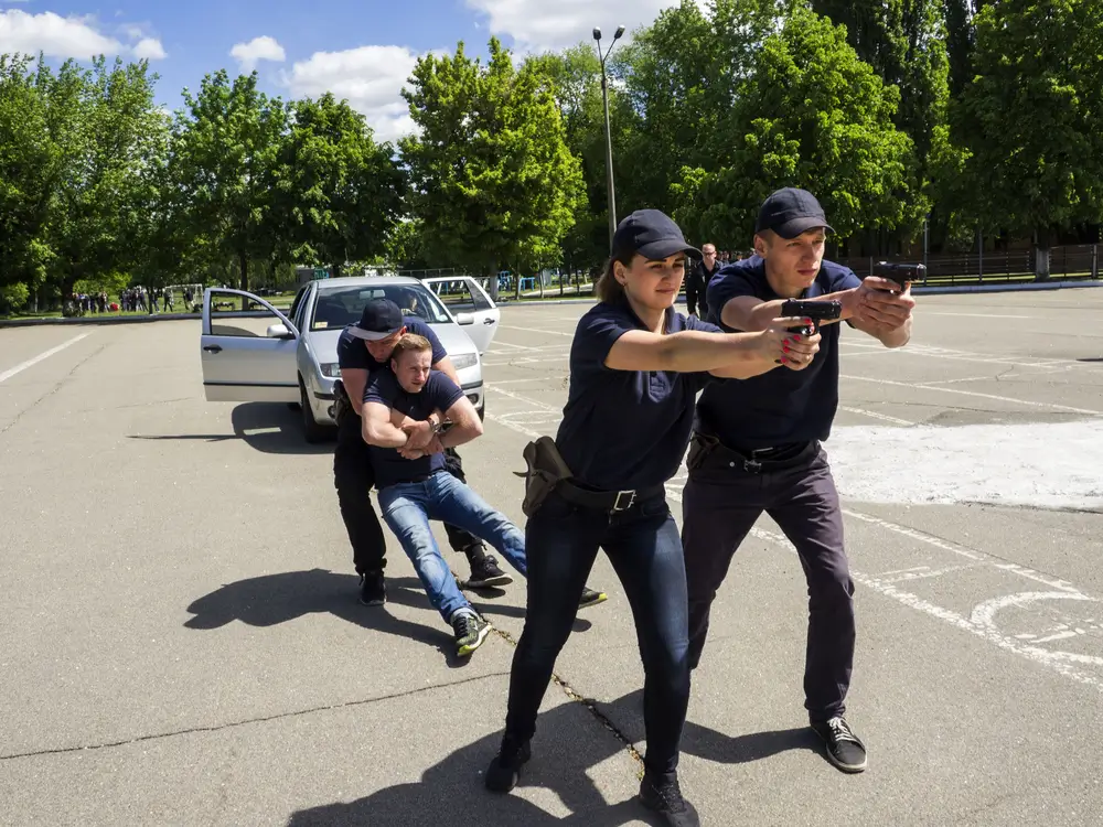 Police recruits practice tactical maneuvers and suspect apprehension during a police recruit training exercise.