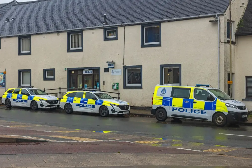 Police Scotland patrol cars and a van parked outside a police station during a response policing shift.